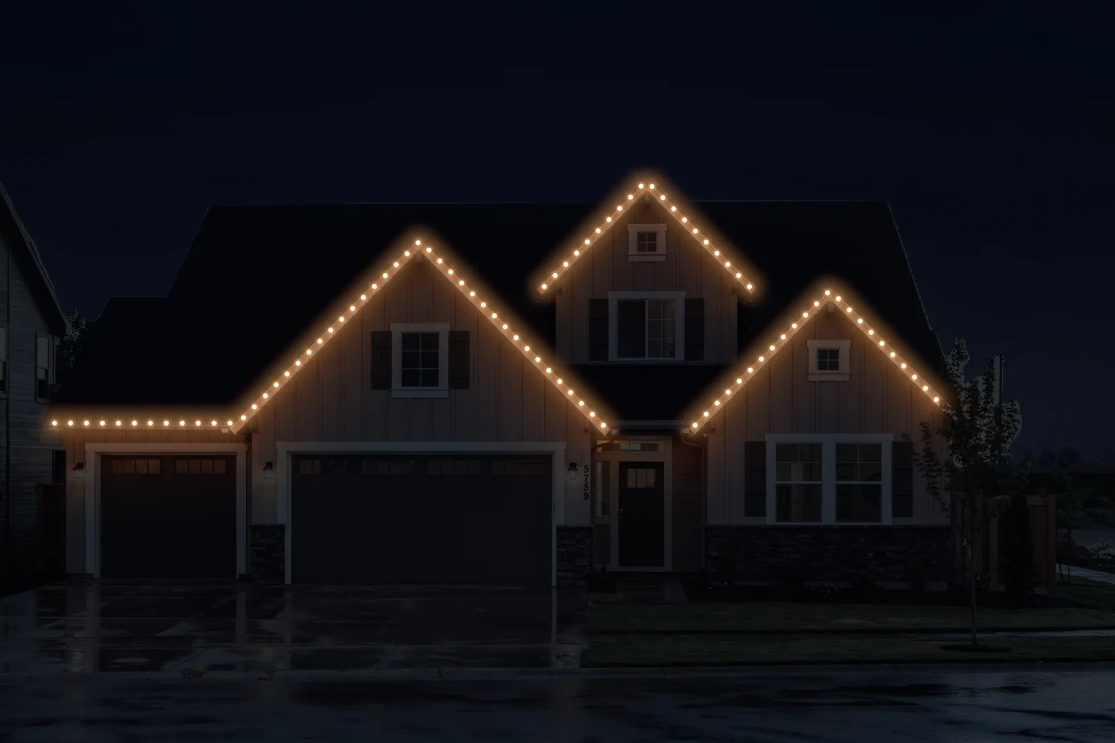 Live preview: the three gables and the garage eave outlined in warm white dots at night