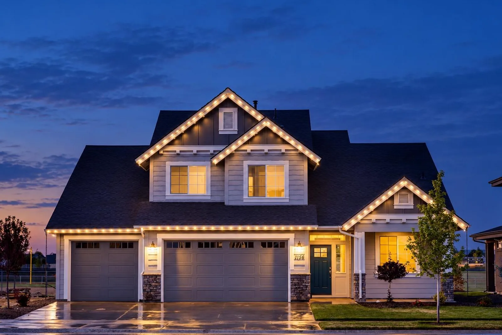 Render of the same house at dusk with warm white permanent lights along the gables and the eave